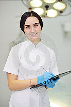 Young pretty doctor girl in white medical dressing gown with stethoscope