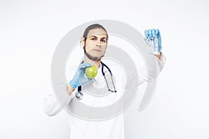 Young pretty doctor with stethoscope holding fruits, vegetables and pills, syringe, healthy food care concept