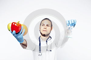 Young pretty doctor with stethoscope holding fruits, vegetables and pills, syringe, healthy food care concept