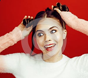 Young pretty emitonal posing teenage girl on bright red background, happy smiling lifestyle people concept