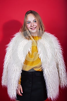 Young pretty emitonal posing teenage girl on bright red background, happy smiling lifestyle people concept