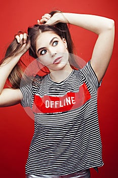 Young pretty emitonal posing teenage girl on bright red background, happy smiling lifestyle people concept