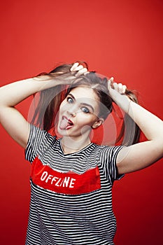 Young pretty emitonal posing teenage girl on bright red background, happy smiling lifestyle people concept