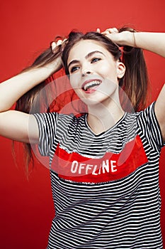 Young pretty emitonal posing teenage girl on bright red background, happy smiling lifestyle people concept