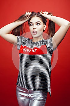 Young pretty emitonal posing teenage girl on bright red background, happy smiling lifestyle people concept