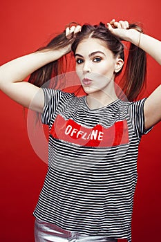Young pretty emitonal posing teenage girl on bright red background, happy smiling lifestyle people concept