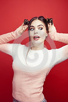 young pretty emitonal posing teenage girl on bright red background, happy smiling lifestyle people concept