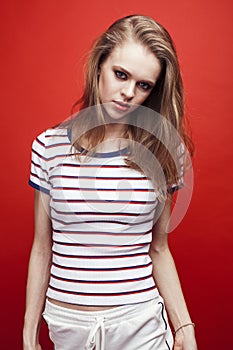 young pretty emitonal posing teenage girl on bright red background, happy smiling lifestyle people concept