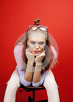 Young pretty emitonal posing teenage girl on bright red background, happy smiling lifestyle people concept