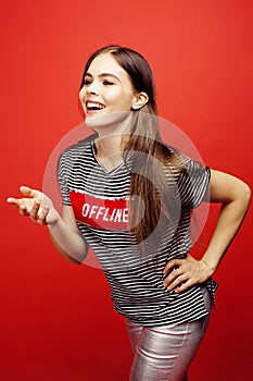 Young pretty emitonal posing teenage girl on bright red background, happy smiling lifestyle people concept