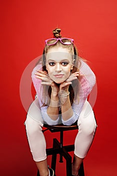 Young pretty emitonal posing teenage girl on bright red background, happy smiling lifestyle people concept