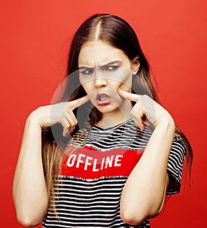 Young pretty emitonal posing teenage girl on bright red background, happy smiling lifestyle people concept