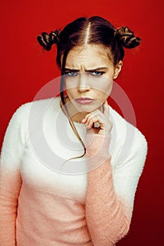 Young pretty emitonal posing teenage girl on bright red background, happy smiling lifestyle people concept closeup