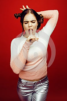 Young pretty emitonal posing teenage girl on bright red background, happy smiling lifestyle people concept closeup