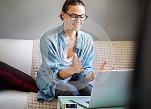 Young pretty european woman with glasses psychologist coach holds an online session on the internet, remote work from home, online
