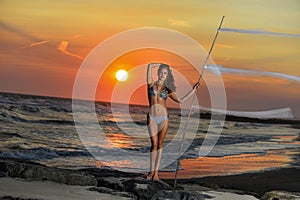 Young pretty fashion sporty woman in bikini posing outdoor on the beach.