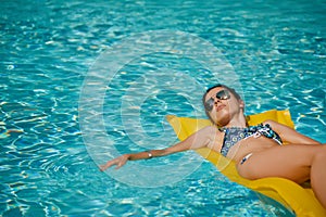 Young pretty fashion woman body posing in summer in pool with cl