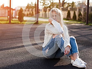 Young pretty fashionable blonde woman dressed in ripped jeans