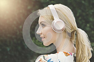 Young Pretty Female Listens to Music on Headphones Smiling and Happy