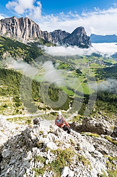Young pretty female mountain climber on a Via Ferrata in the Dolomites in Alta Badia