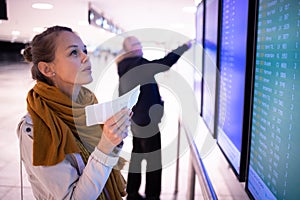 Young, pretty female traveler learning about her flight being canceled