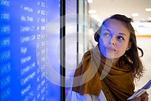 Young, pretty female traveler learning about her flight being canceled