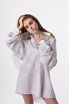 Young pretty female wearing shirt posing in studio with bare feet, model tests