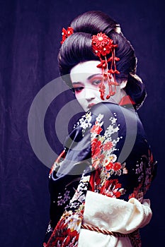 young pretty geisha in kimono with sakura and decoration on blac