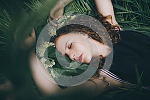 A Young Pretty Girl In Black Dress Laying On A Grass And Dreaming