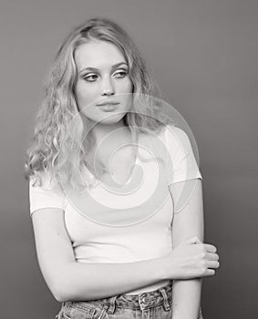 young pretty girl with blond curly hair posing cheerful on brown background, lifestyle people concept