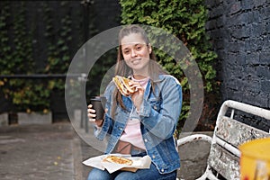 Young pretty girl with fast food - sandwitch and coffee