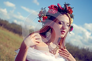 Young pretty girl in flower wreath and ethnic