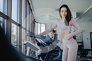 Young pretty girl goes in for sports on a treadmill in the gym. anaerobic sports exercises indoors