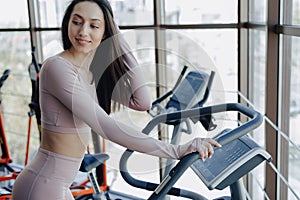 Young pretty girl goes in for sports on a treadmill in the gym. anaerobic sports exercises indoors