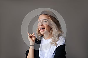 Young pretty girl holding finger up having idea and posing.