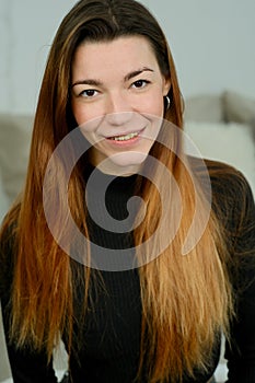 Young pretty girl with long red hair in a black shirt