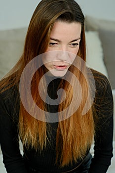 Young pretty girl with long red hair in a black shirt