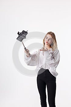 Young pretty girl making self portrait with smartphone attached to selfie stick