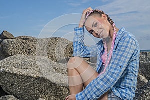 Young pretty girl with pink plaits between rocks