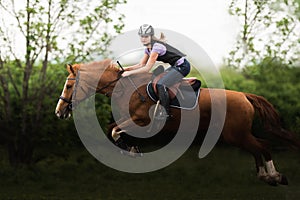 Young pretty girl riding a horse