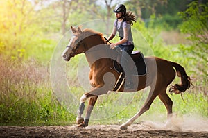 Young pretty girl riding a horse with backlit leaves behind in s photo