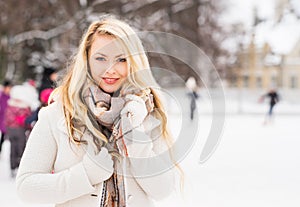 Young and pretty girl skating on outdoor ice-rink