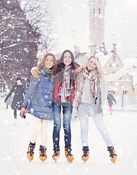 Young and pretty girl skating on outdoor open air ice-rink at wi