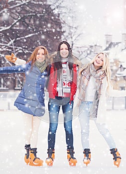 Young and pretty girl skating on outdoor open air ice-rink at wi