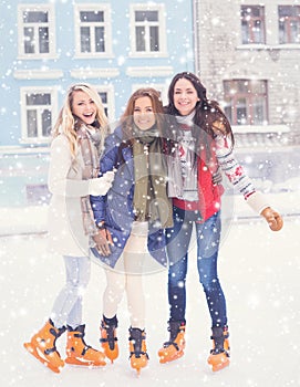 Young and pretty girl skating on outdoor open air ice-rink at wi