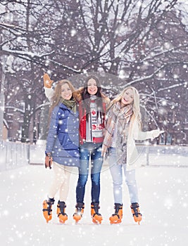 Young and pretty girl skating on outdoor open air ice-rink at wi