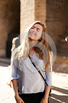 Young pretty girl standing in brick wall background.