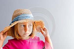 Young pretty girl in straw hat looking away