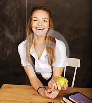 Young pretty girl student in classroom at blackboard