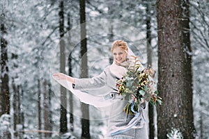 The young pretty girl waits for her lover in the middle of the mountains covered with snow